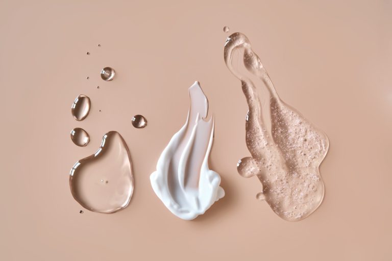 Texturas de crema y sérum sobre fondo beige